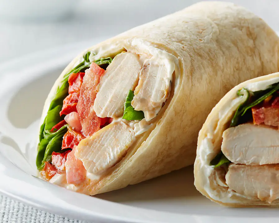 Chicken, tomato and spinach wrap cut in half